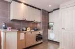 This charming kitchen boasts a modern design with light wood cabinetry and sleek appliances.