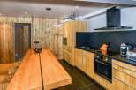 This stunning kitchen boasts a modern design with a rustic touch, featuring wooden cabinetry and a sleek black countertop.