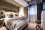 This luxurious bedroom boasts a stunning wood-paneled ceiling and walls, creating a cozy and inviting atmosphere.