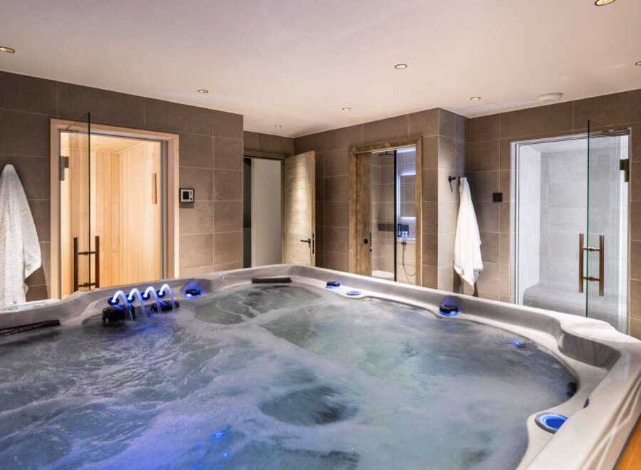 Indulge in ultimate relaxation in this luxurious home spa, featuring a spacious hot tub with soothing jets and ambient lighting.