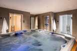 Indulge in ultimate relaxation in this luxurious home spa, featuring a spacious hot tub with soothing jets and ambient lighting.