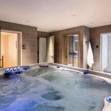 Indulge in ultimate relaxation in this luxurious home spa, featuring a spacious hot tub with soothing jets and ambient lighting.