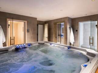 Indulge in ultimate relaxation in this luxurious home spa, featuring a spacious hot tub with soothing jets and ambient lighting.
