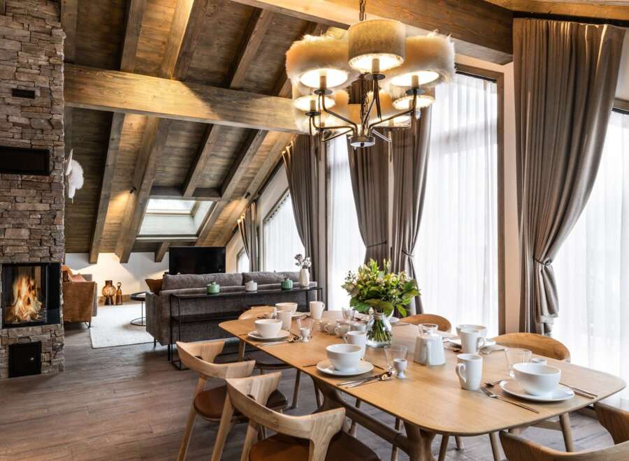 This stunning chalet boasts a spacious open-plan living area with a cozy fireplace, perfect for relaxing after a day on the slopes.