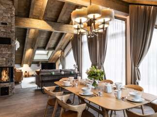This stunning chalet boasts a spacious open-plan living area with a cozy fireplace, perfect for relaxing after a day on the slopes.