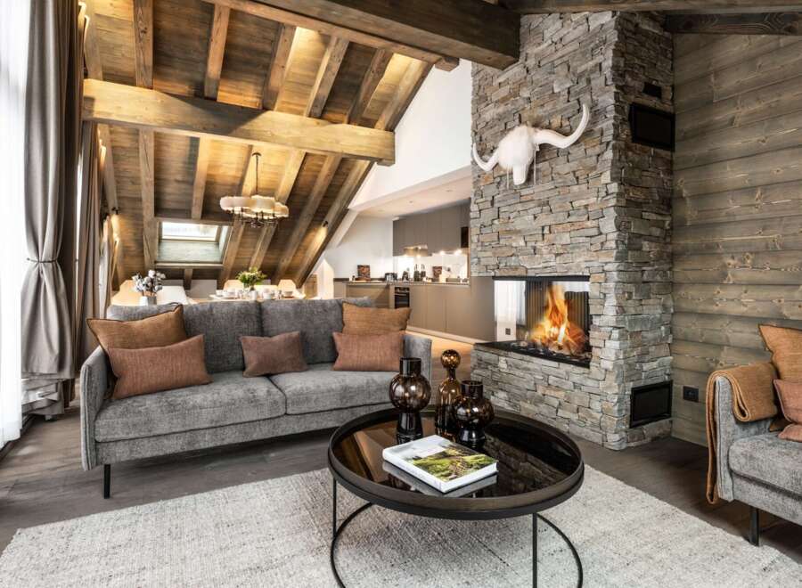 This stunning chalet boasts a spacious open-plan living area with a cozy fireplace, perfect for relaxing after a day on the slopes.