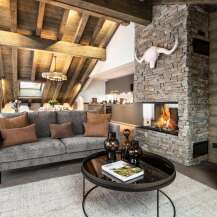 This stunning chalet boasts a spacious open-plan living area with a cozy fireplace, perfect for relaxing after a day on the slopes.