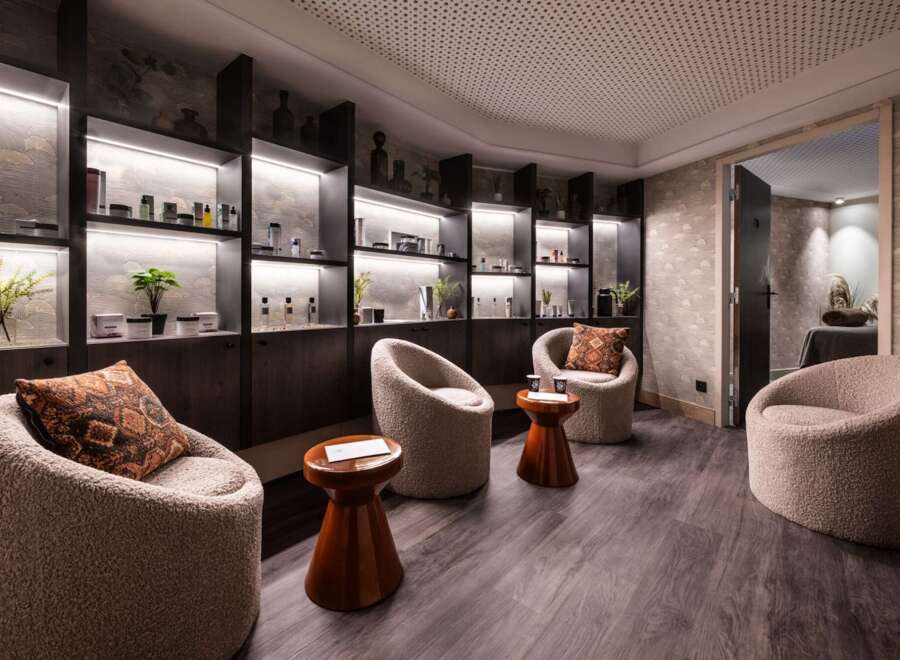 Relax in our luxurious spa, featuring plush seating areas and uniquely designed shelves stocked with premium skincare products.