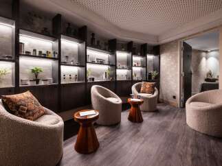Relax in our luxurious spa, featuring plush seating areas and uniquely designed shelves stocked with premium skincare products.