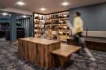 This stunning ski rental shop boasts a modern design with rustic wooden furniture and sleek shelving units showcasing an array of skis, boots, and helmets.
