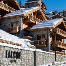 Nestled in a snow-covered mountainside, Falcon Megève offers luxurious chalets with stunning wooden balconies and stone exteriors.