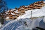 Luxury chalet-style homes nestled on a snow-covered hillside, offering stunning mountain views and a serene winter escape.
