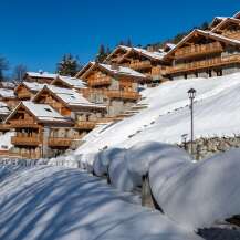 Luxury chalet-style homes nestled on a snow-covered hillside, offering stunning mountain views and a serene winter escape.