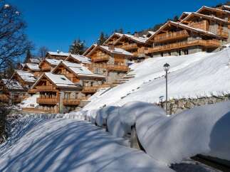 Luxury chalet-style homes nestled on a snow-covered hillside, offering stunning mountain views and a serene winter escape.