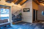 This stunning chalet boasts a spacious lobby with a cozy seating area, offering breathtaking mountain views through large windows.