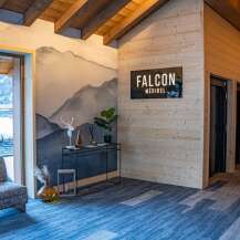 This stunning chalet boasts a spacious lobby with a cozy seating area, offering breathtaking mountain views through large windows.