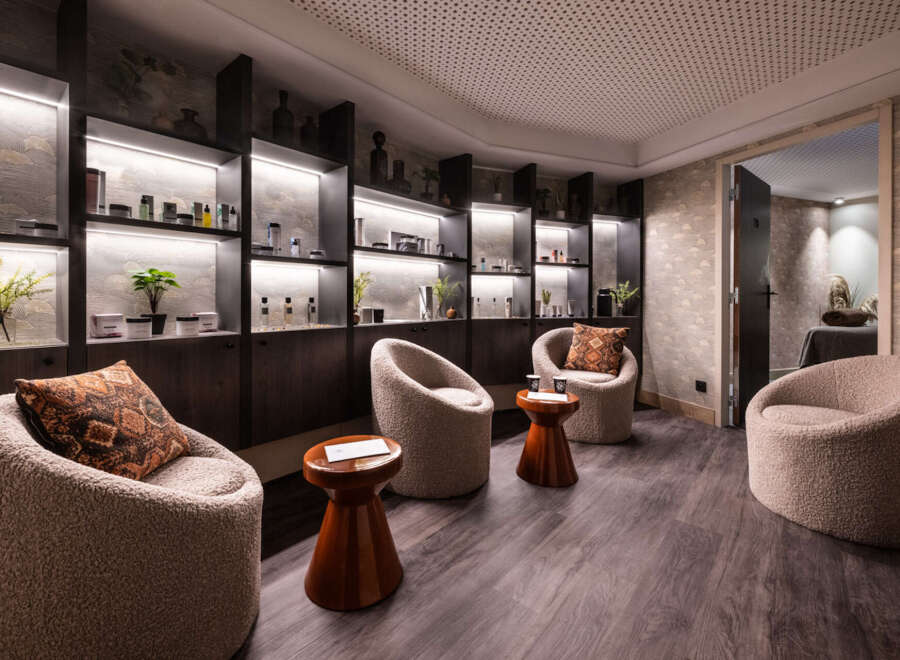 Relax in style at our luxurious spa, featuring plush seating areas and uniquely designed shelves showcasing our premium skincare products.