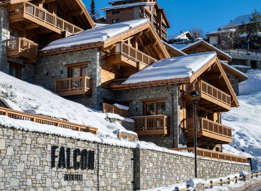 Nestled in a snow-covered mountainside, the Falcon Megève showcases stunning architecture with its stone and wood exterior.