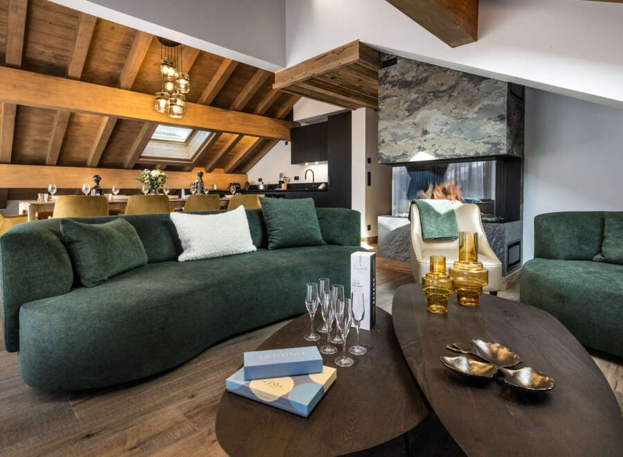 This luxurious chalet boasts a spacious open-plan living area with a stunning fireplace, perfect for cozy evenings.