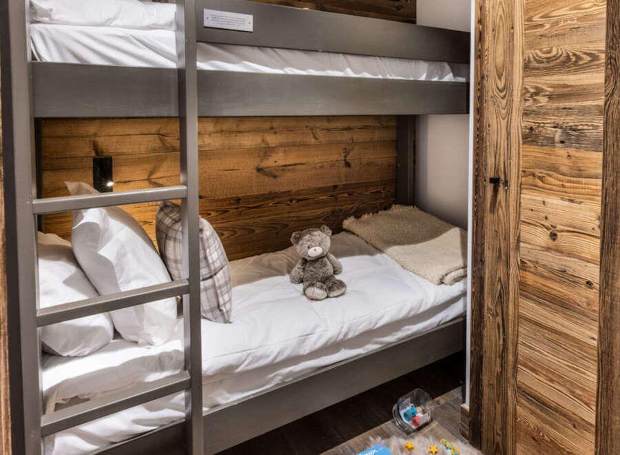 Cozy bunk beds nestled in a rustic wooden room, perfect for a family getaway.