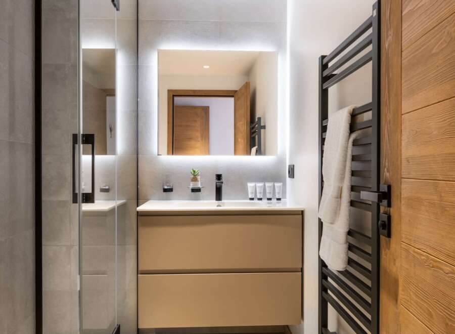 This modern bathroom boasts a sleek design with a spacious walk-in shower and a stylish vanity.