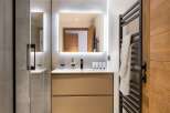 This modern bathroom boasts a sleek design with a spacious walk-in shower and a stylish vanity.