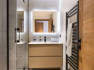 This modern bathroom boasts a sleek design with a spacious walk-in shower and a stylish vanity.