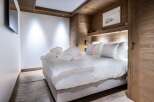 Experience luxury in this stunning bedroom featuring a cozy king-sized bed with plush bedding and fluffy pillows.