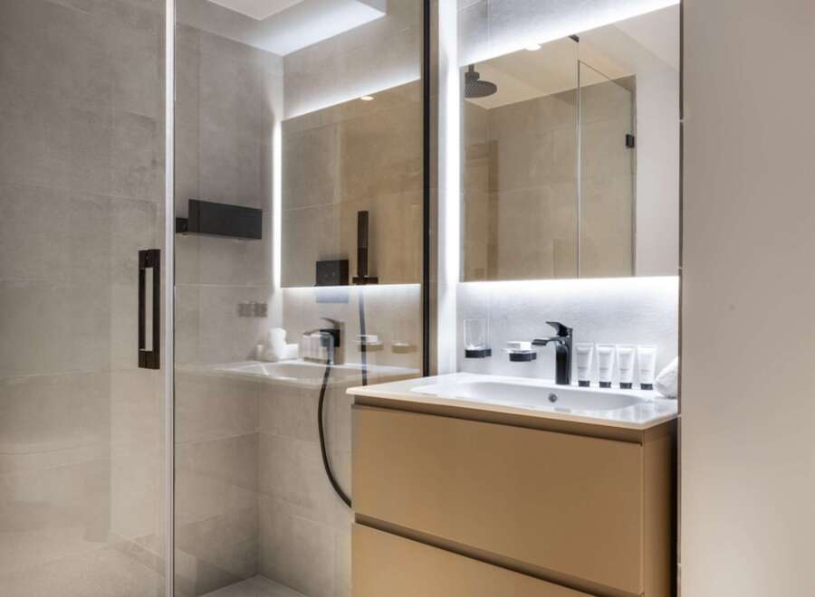 Step into a modern bathroom oasis, featuring a sleek glass-enclosed shower and a stylish floating vanity.