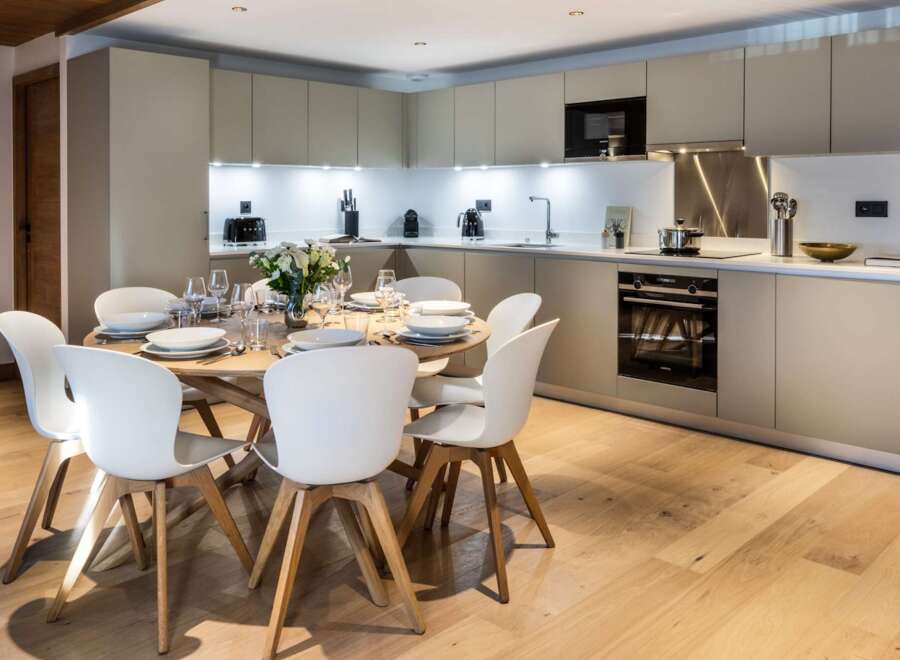 This stunning kitchen and dining area is the heart of the home, featuring modern cabinetry and a sleek design.