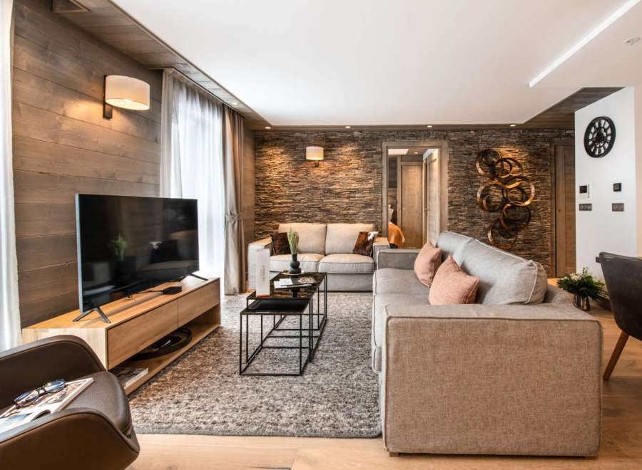 This stunning apartment boasts a spacious living area with a cozy fireplace, plush sofas, and large windows offering ample natural light.