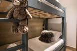 Cozy bunk beds with plush teddy bear and soft blankets create a warm and inviting atmosphere for children.