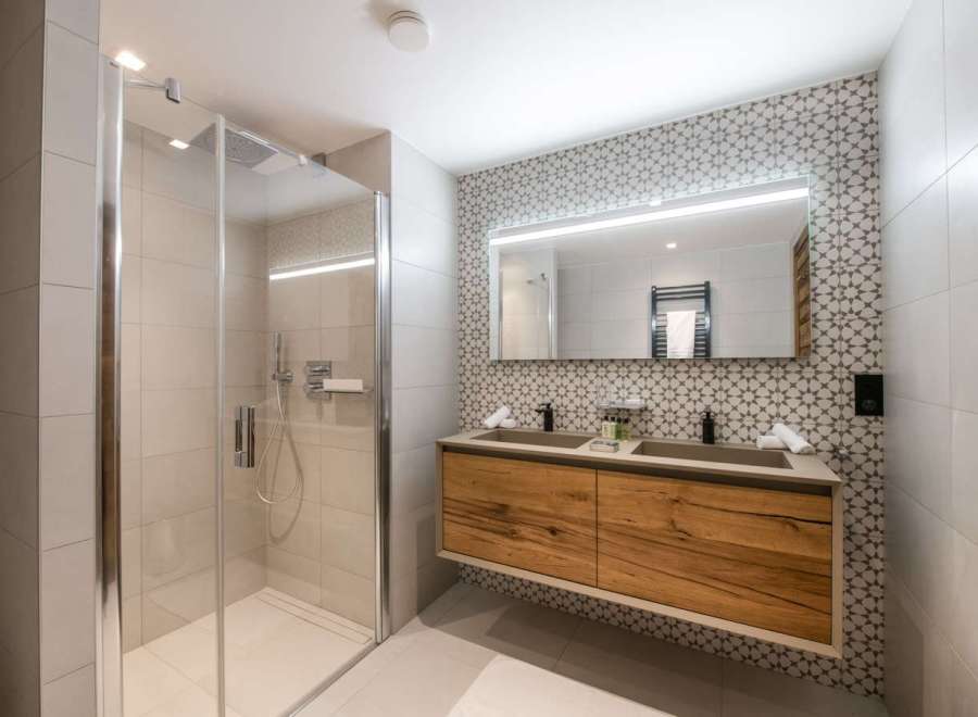 This luxurious bathroom boasts a spacious walk-in shower with modern fixtures and a sleek glass enclosure.