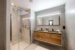 This luxurious bathroom boasts a spacious walk-in shower with modern fixtures and a sleek glass enclosure.