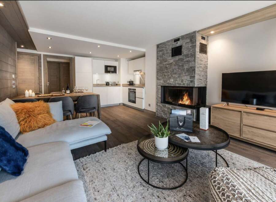 This stunning apartment boasts a spacious open-plan living area with a cozy fireplace, perfect for relaxing after a day on the slopes.