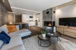 This stunning apartment boasts a spacious open-plan living area with a cozy fireplace, perfect for relaxing after a day on the slopes.