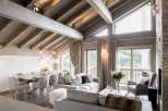 This stunning chalet boasts a spacious open-plan living area with vaulted wooden ceilings and large windows offering breathtaking views.