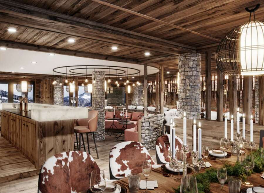 This luxurious chalet boasts a stunning dining area with a rustic-chic design, featuring a long wooden table adorned with candles and greenery, surrounded by cowhide chairs.