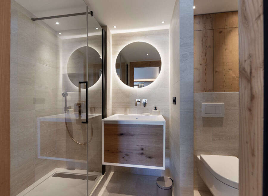 Step into a modern bathroom oasis, featuring a sleek glass shower enclosure and a stylish floating vanity.