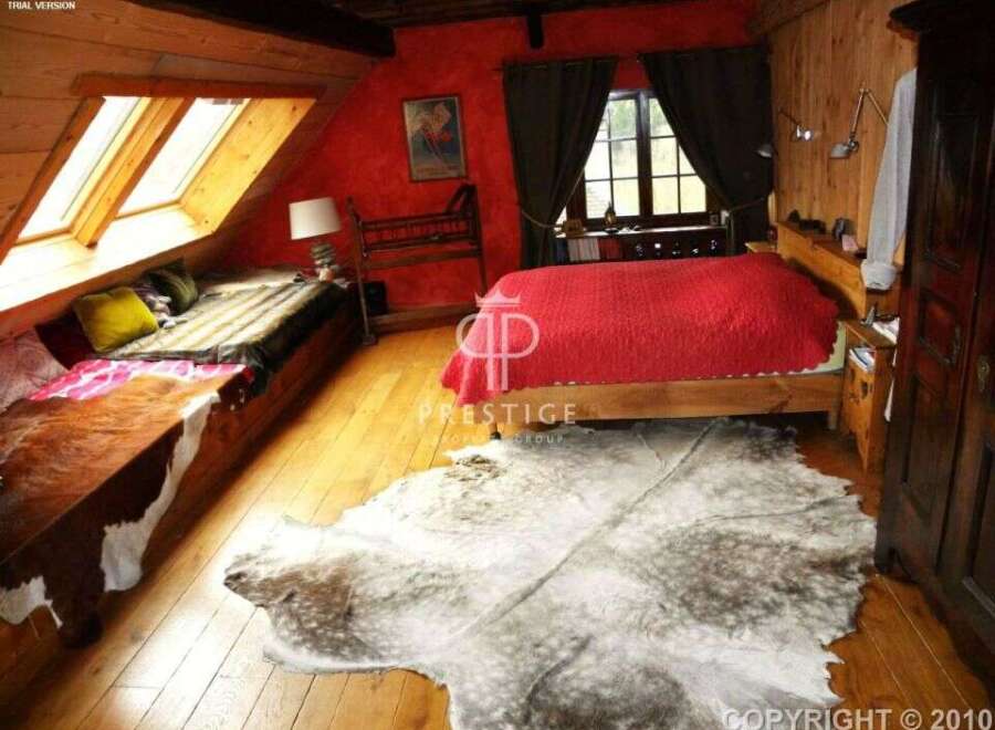 This cozy bedroom features a unique design with wooden accents and a vibrant red wall.