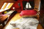 This cozy bedroom features a unique design with wooden accents and a vibrant red wall.