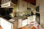 Discover a charming kitchen with classic cabinetry and a sleek cooktop, perfect for culinary enthusiasts.