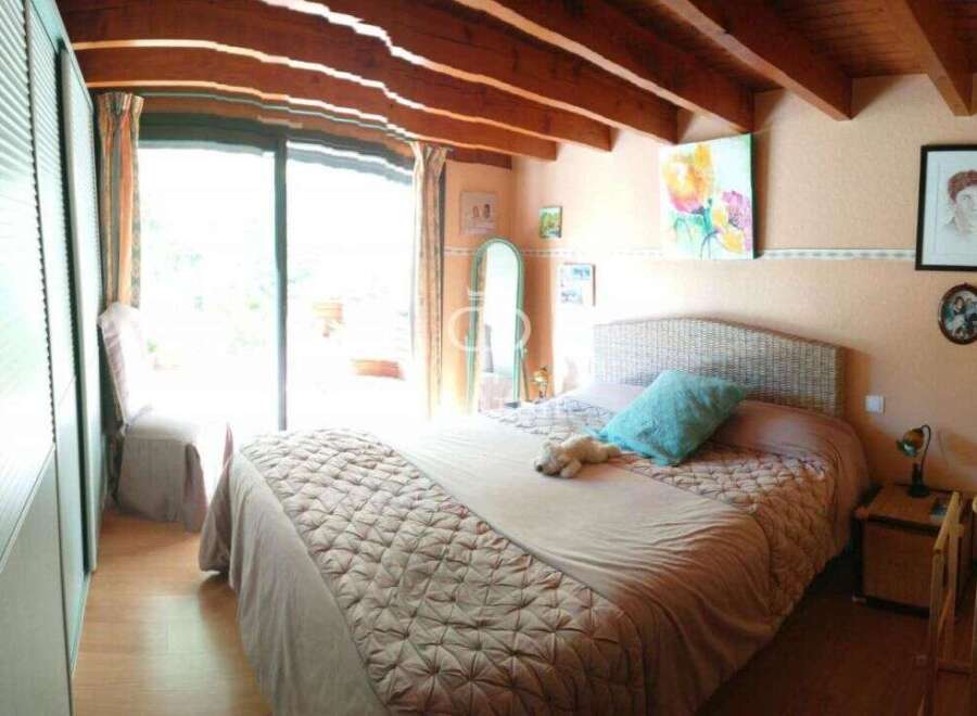 Cozy bedroom with a rustic touch, featuring exposed wooden beams and a comfortable bed.