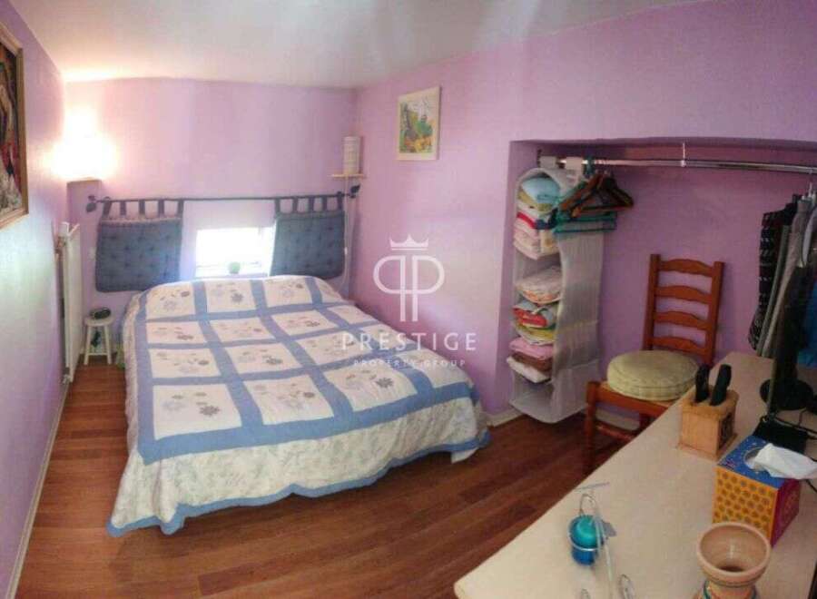 Discover this charming bedroom featuring a cozy bed with a stylish quilt and a built-in closet for ample storage.