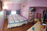 Discover this charming bedroom featuring a cozy bed with a stylish quilt and a built-in closet for ample storage.