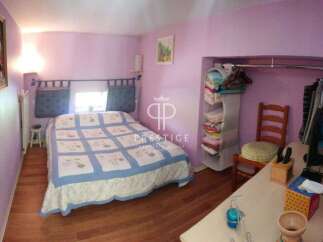 Discover this charming bedroom featuring a cozy bed with a stylish quilt and a built-in closet for ample storage.