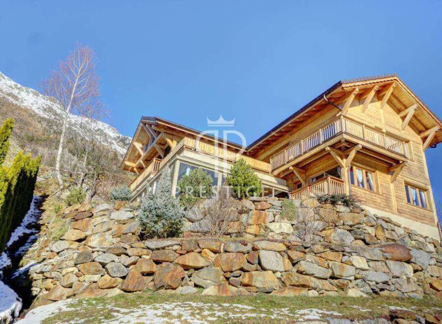 Discover a stunning wooden chalet nestled in a picturesque mountain setting.