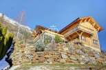 Discover a stunning wooden chalet nestled in a picturesque mountain setting.