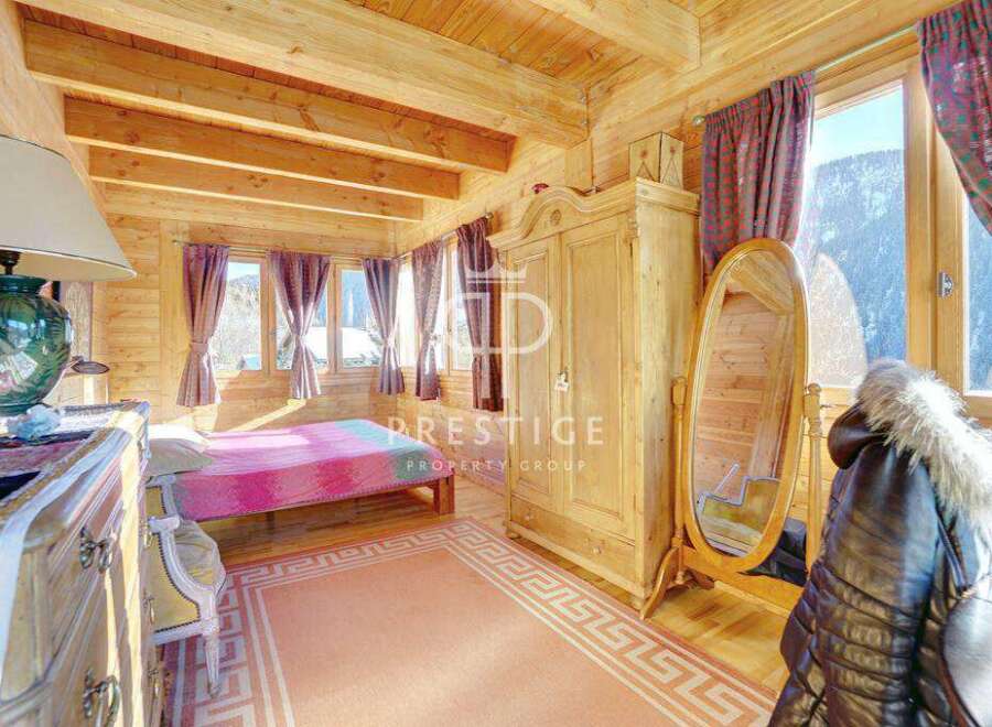 Discover the charm of this cozy bedroom, featuring a warm wooden interior and a touch of elegance.