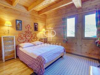 Cozy bedroom with wooden walls and ceiling, creating a warm and inviting atmosphere.